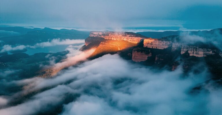 Stunning sunrise over misty mountain range with clouds below, creating a dramatic natural landscape.