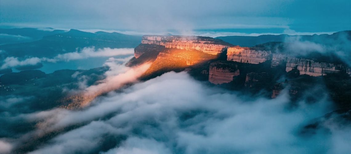 Stunning sunrise over misty mountain range with clouds below, creating a dramatic natural landscape.